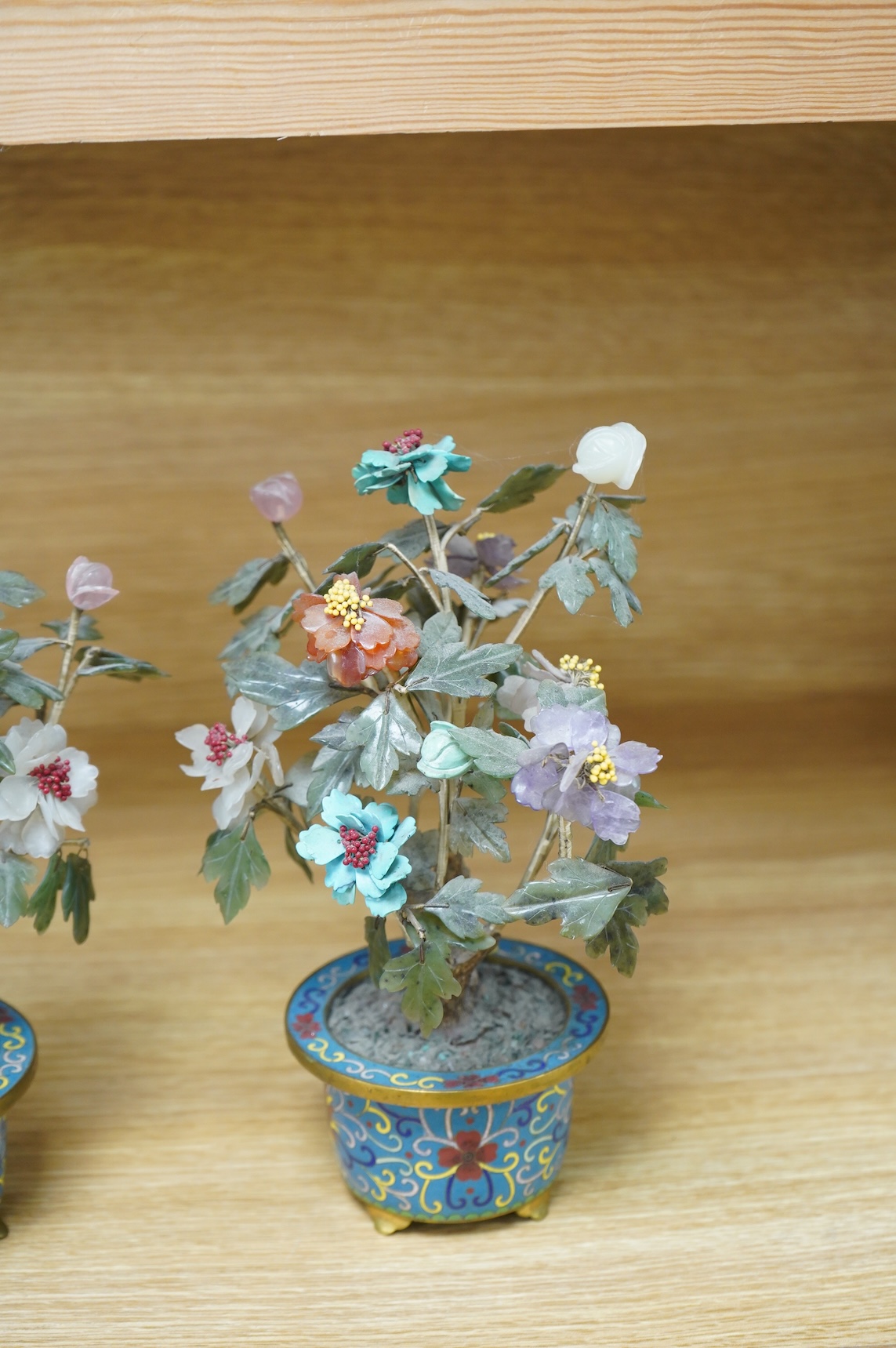 A pair of Chinese hardstone trees, in cloisonne jardinieres, 23cm high